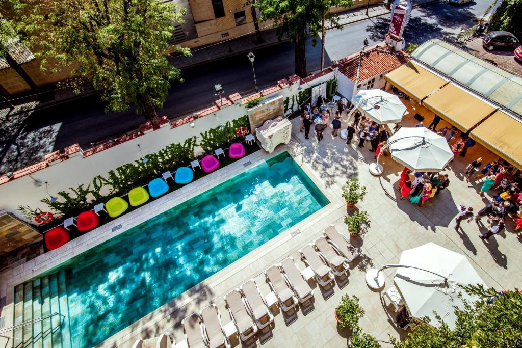 格拉纳达洛杉矶水疗酒店的享有带遮阳伞的游泳池的顶部景致