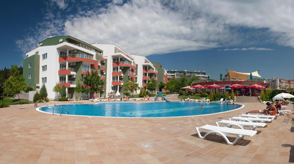 阳光海滩Green Fort Private Apartments的一个带椅子和遮阳伞的游泳池的度假酒店