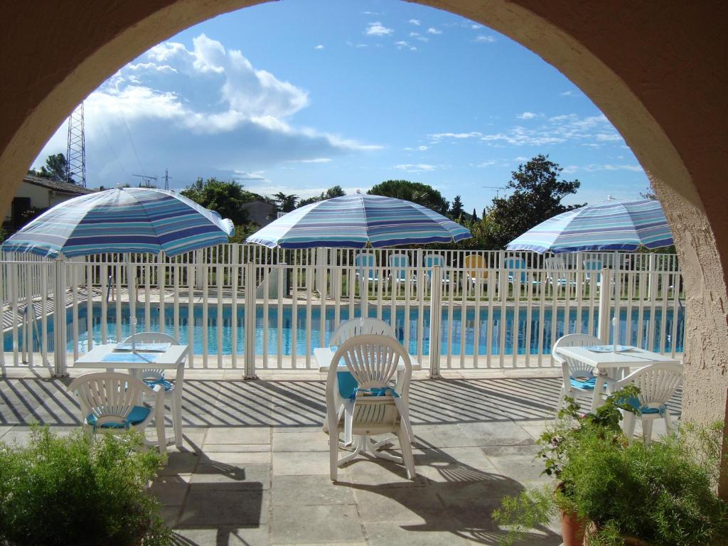 佩梅纳德德拉波斯特酒店的游泳池旁带椅子和遮阳伞的天井