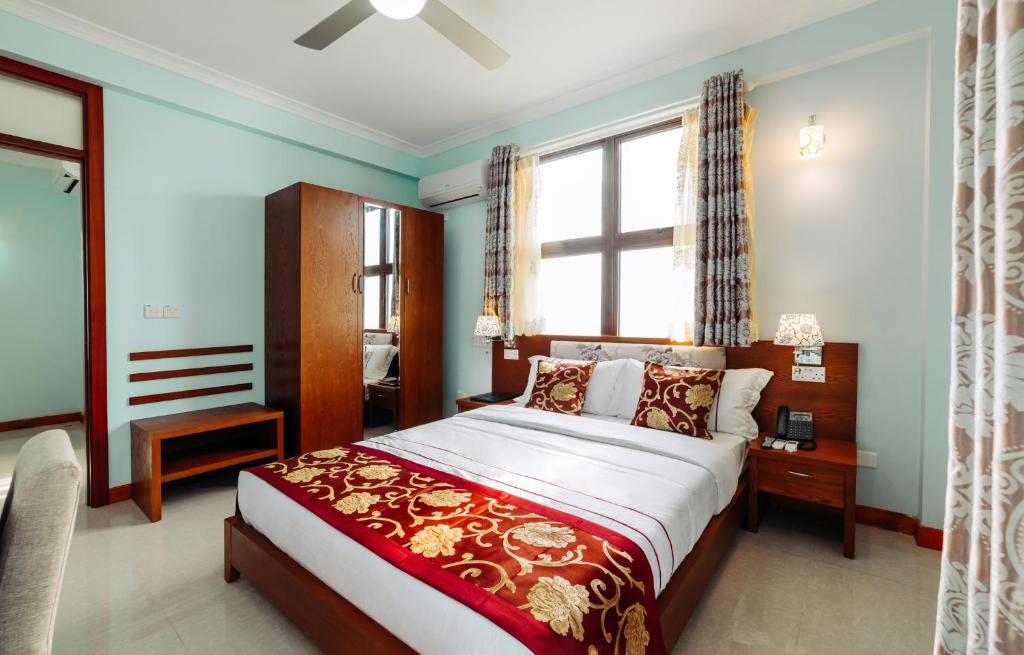Hithadhoo利基戴酒店的一间卧室设有一张大床和一个窗户。