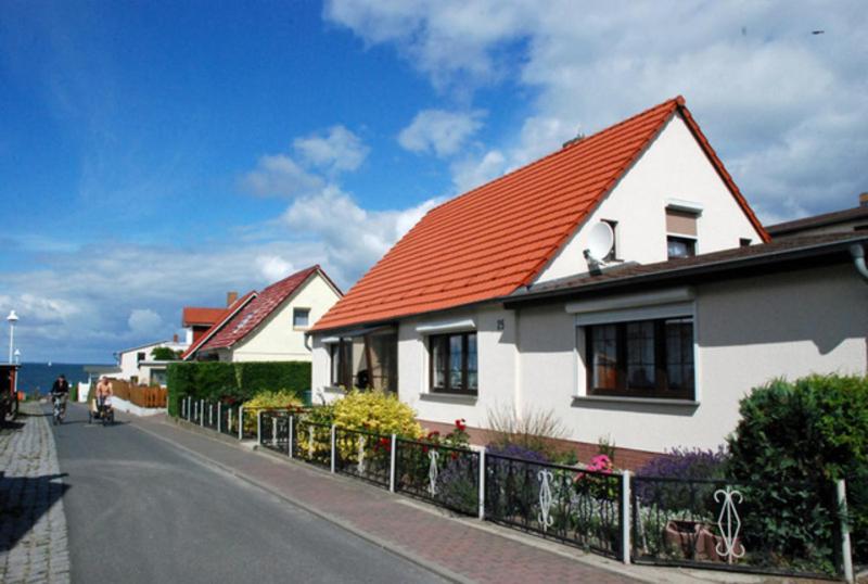 Klein ZickerFerienhaus Christa的一条白色房子,在街上有橙色的屋顶