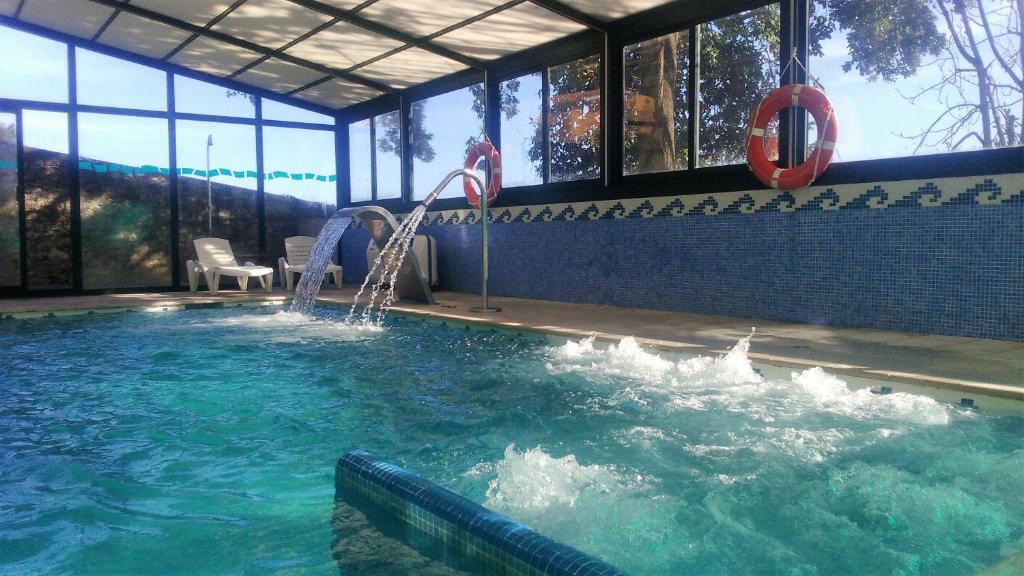桑坦德圣米仑酒店的一座大楼内带水滑梯的游泳池