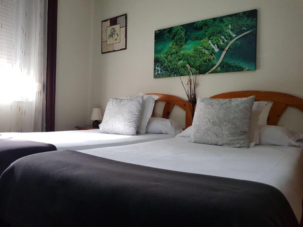 潘普洛纳莱尔旅馆的一间卧室设有两张床,墙上挂着一幅画