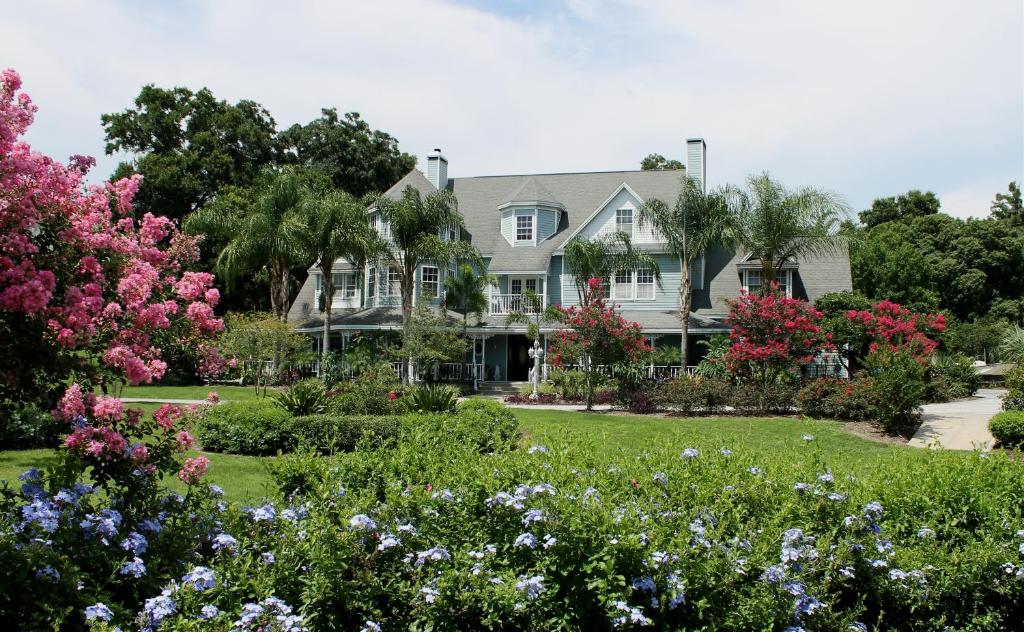 芒特多拉Heron Cay Lakeview Bed & Breakfast的院子里鲜花盛开的大房子