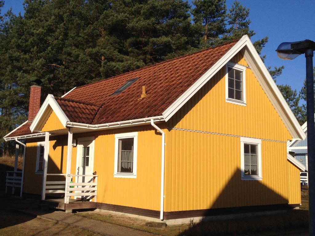 乌塞林Haus-am-See的棕色屋顶的黄色房子