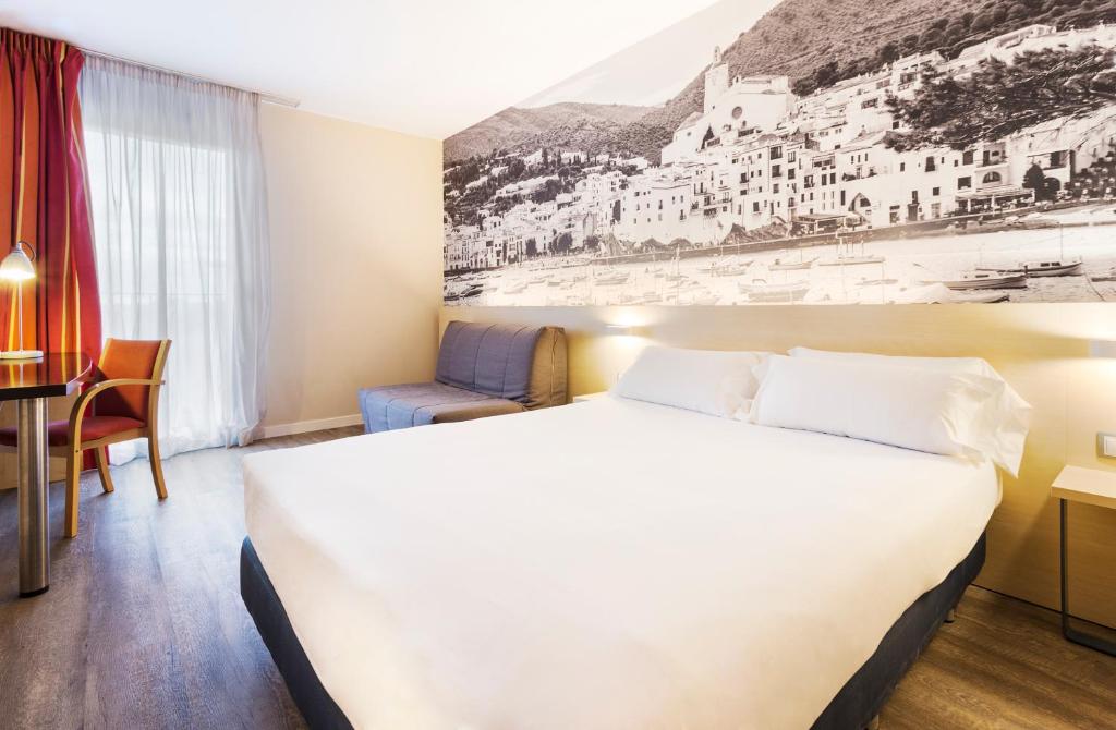 萨尔特B&B HOTEL Girona 3的酒店客房设有一张大床和一张书桌。