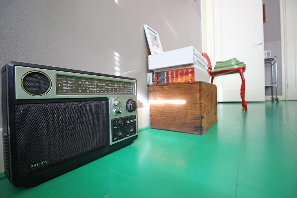 阿姆斯特丹Cafe Modern的坐在桌子旁的绿色地板上的收音机