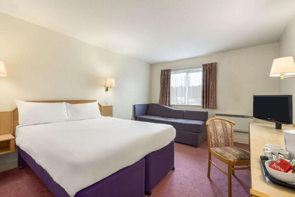 Tibshelf特菲尔德戴斯酒店 - 提比舍尔夫的酒店客房设有一张大床和一张沙发。