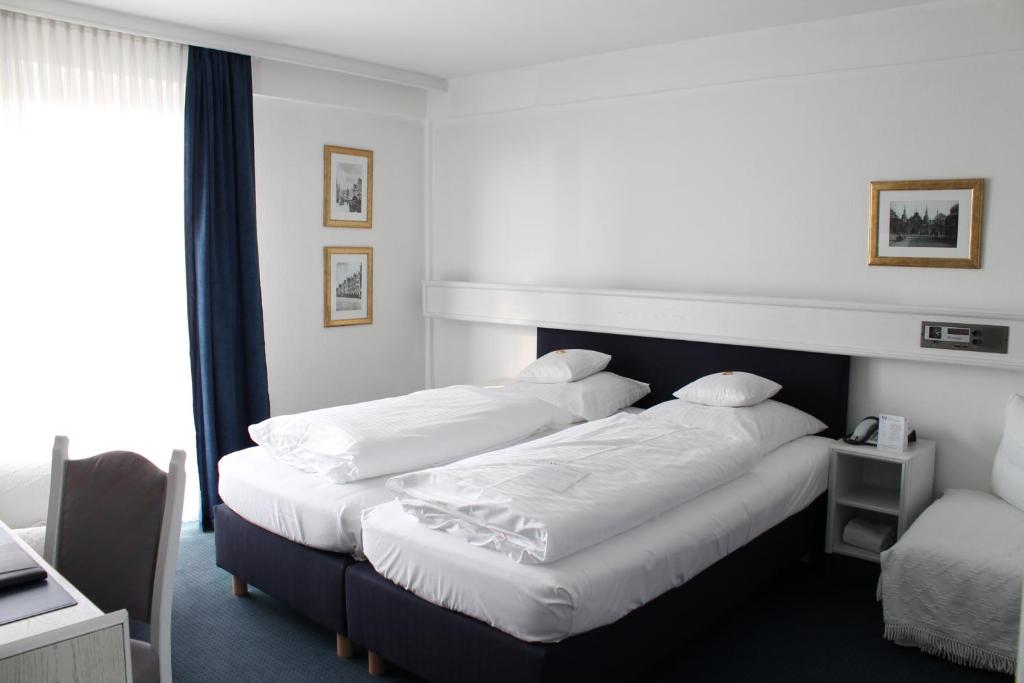 明斯特温索斯特酒店的酒店客房设有两张床和窗户。