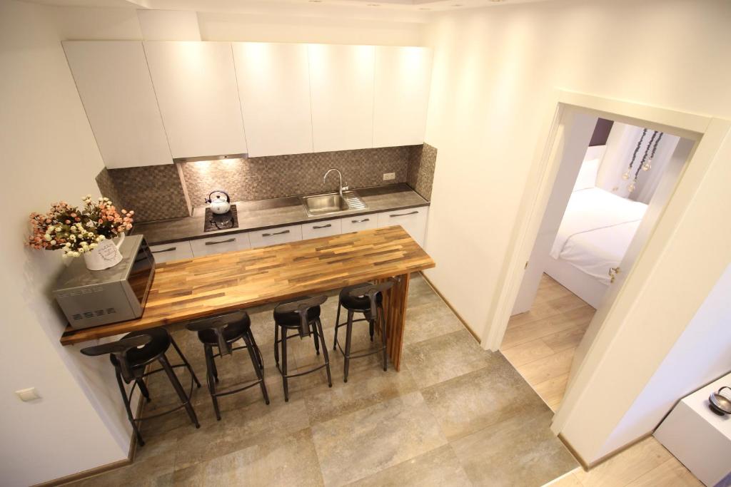 第比利斯Super Luxury Apartments的一个带木桌和椅子的小厨房