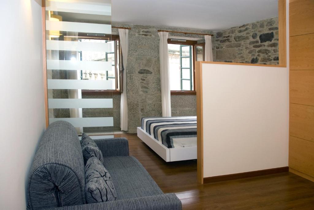 圣地亚哥－德孔波斯特拉多莫斯斯特拉公寓式酒店的客厅配有沙发和1张床