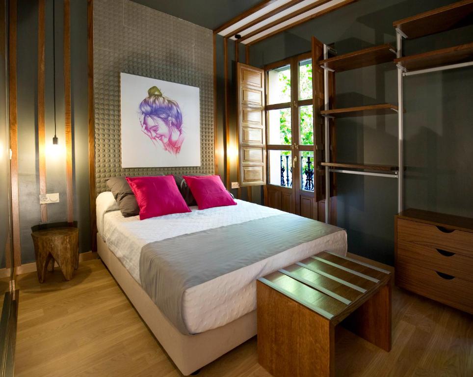 萨拉曼卡San Justo Plaza的卧室配有一张带粉红色枕头的大床