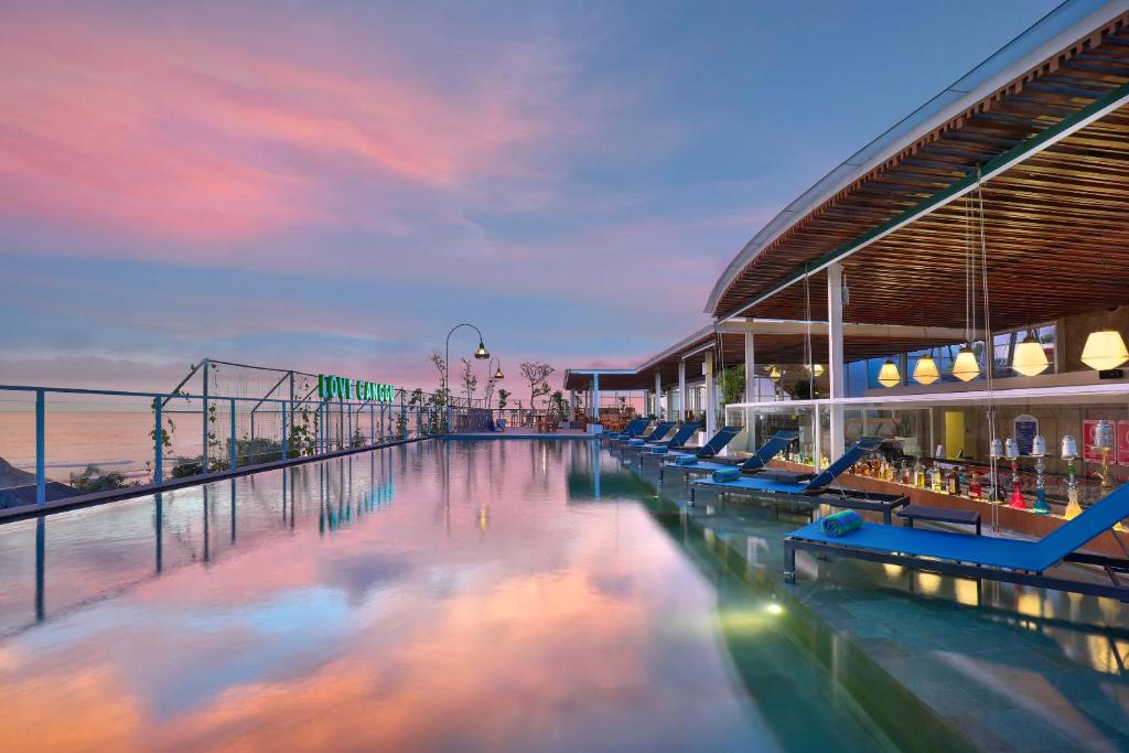 坎古ASTON Canggu Beach Resort的一座带游泳池的建筑,毗邻大海