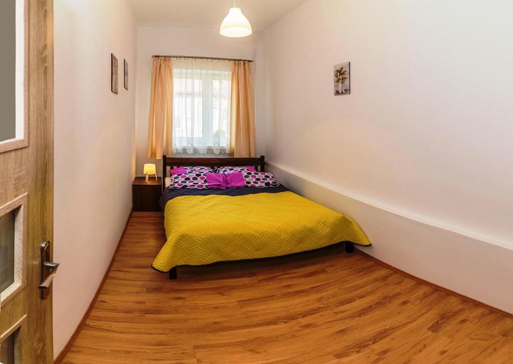 库多瓦-兹德鲁伊Apartament Jaśminowy的小卧室配有一张黄色毯子床