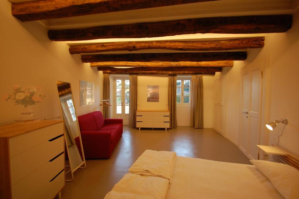 吉法Rustico Moderno的客厅配有床和红色沙发