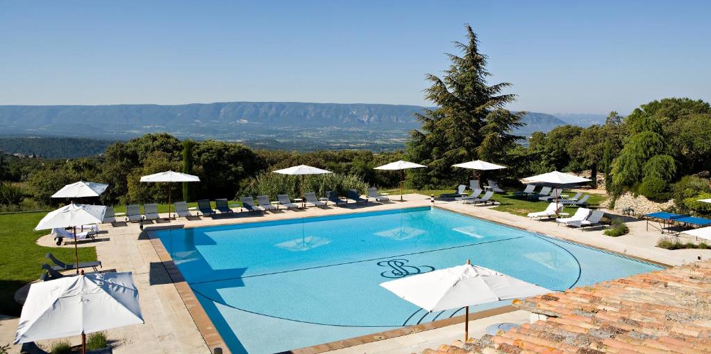戈尔德波利斯温泉酒店的度假村顶部的游泳池配有椅子和遮阳伞