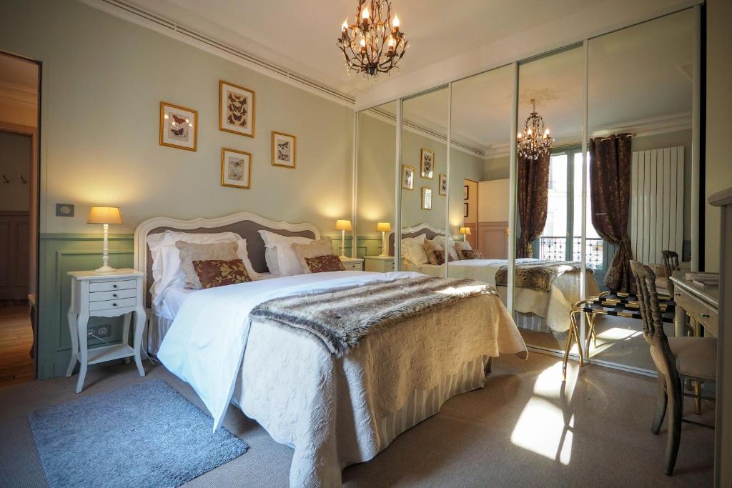 巴黎住宿加早餐：卢浮宫优雅套房的一间卧室配有两张床和吊灯。