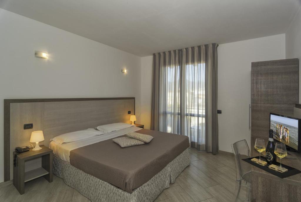 利多迪卡马约雷Hotel Lido Inn的一间卧室配有一张床和一台平面电视