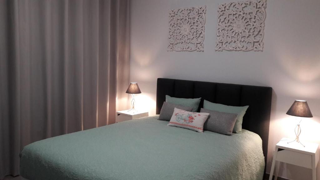 马达莱纳AL - BOA NOVA的一间卧室配有一张床,两台桌子上放着两盏灯