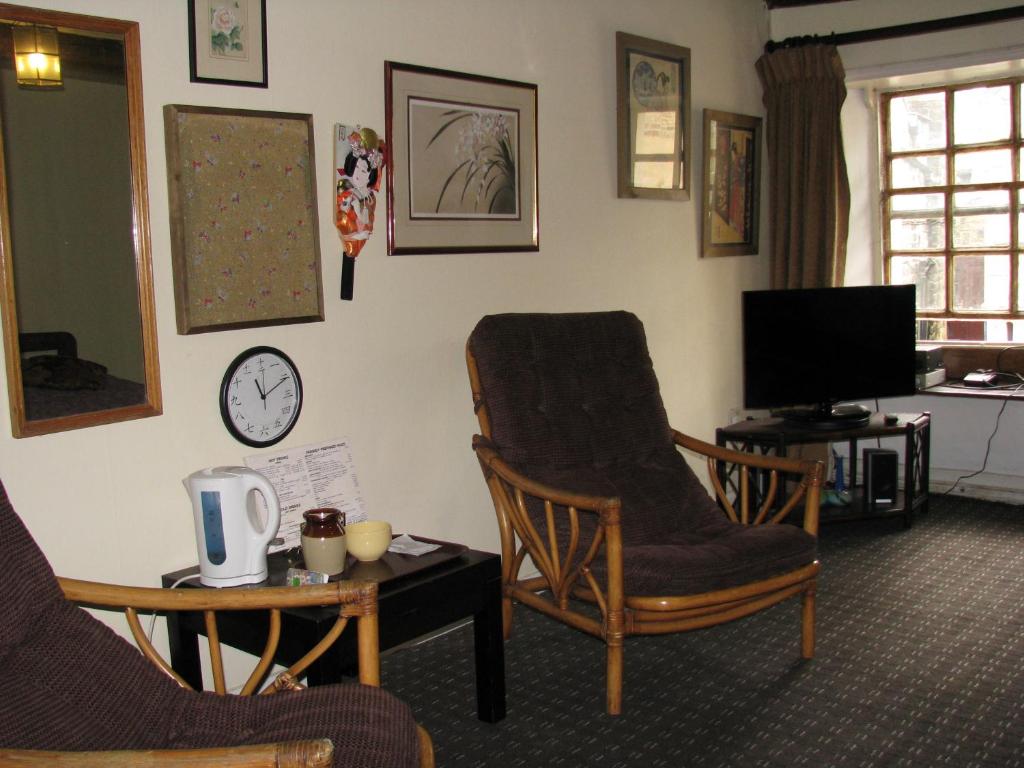 哈罗盖特Sweetheart House的客厅配有两把椅子和电视