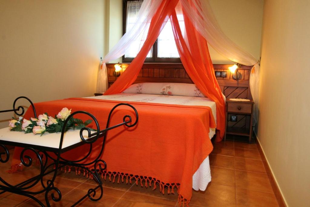 Hoz de Anero托拉亚阿帕特蒙托斯公寓的一间卧室配有一张带橙色毯子和窗户的床。