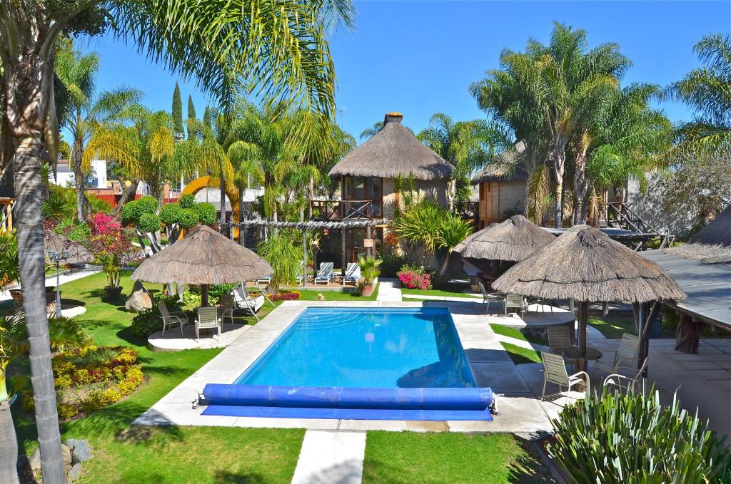 阿特利斯科拉阿尔迪酒店及水疗中心的一个带游泳池和遮阳伞的度假村