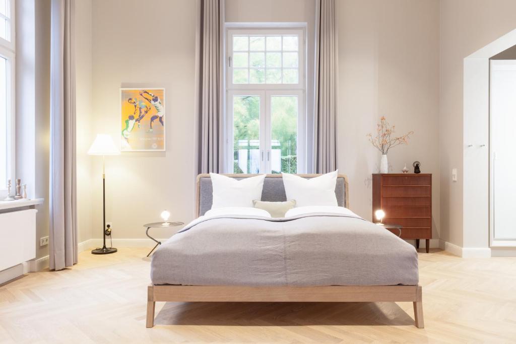 黑灵斯多夫OSTKÜSTE - Villa Staudt Design Apartments的白色的卧室设有一张大床和一个窗户
