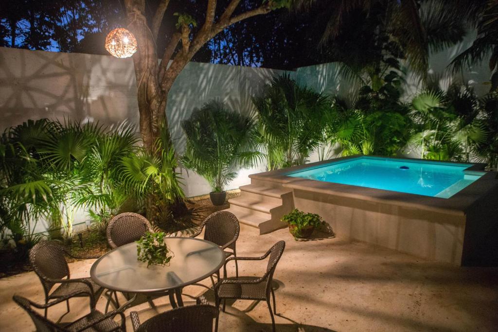 坎昆Cozy house downtown Cancun的一个带桌椅的庭院和一个游泳池