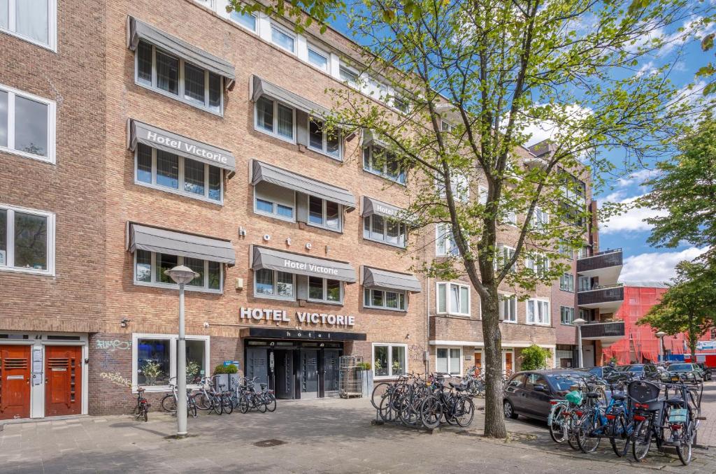 阿姆斯特丹维多利亚酒店的一座砖砌建筑,外面有自行车停放