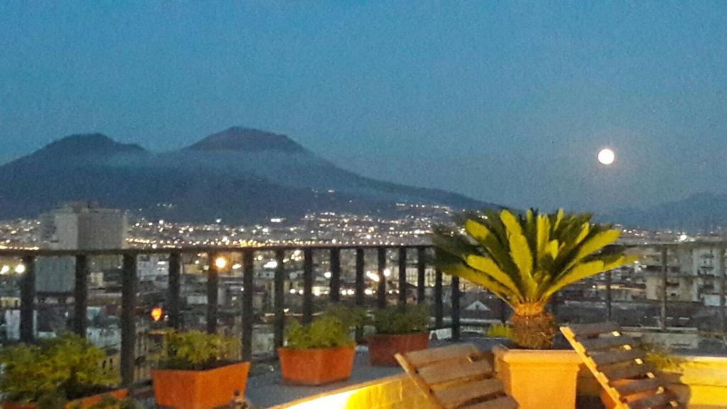 那不勒斯A wonderful penthouse in Naples的阳台,晚上可欣赏到城市景观