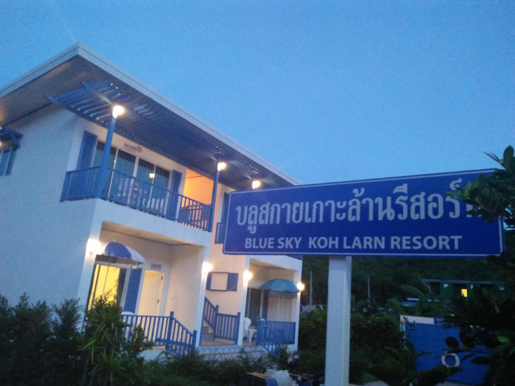 格兰岛Blue sky Koh larn Resort的前面有蓝色标志的建筑