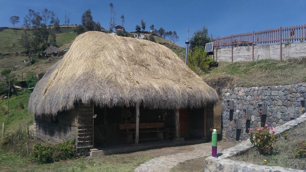 Hacienda ColtaTurismo Comunitario La Esperanza的山坡上带草屋顶的小小屋