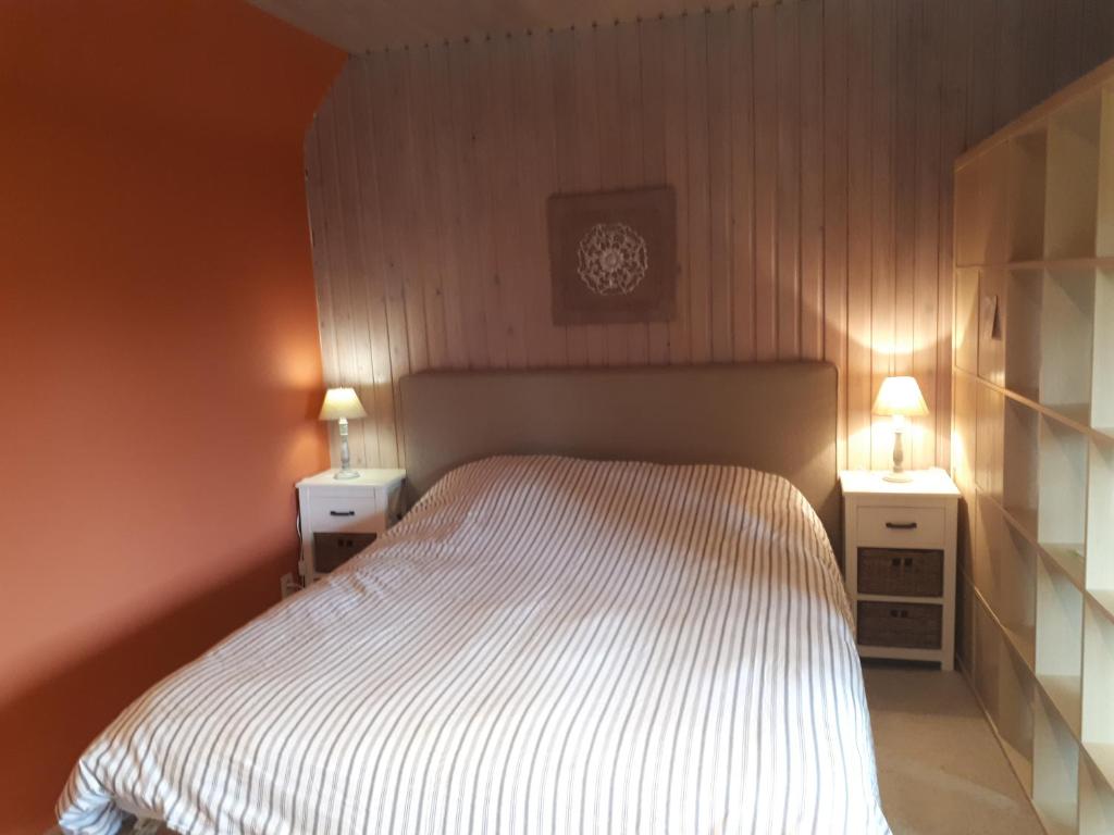 Gesves布里昂萨特乡村民宿的一间卧室配有一张带2个床头柜和1个时钟的床