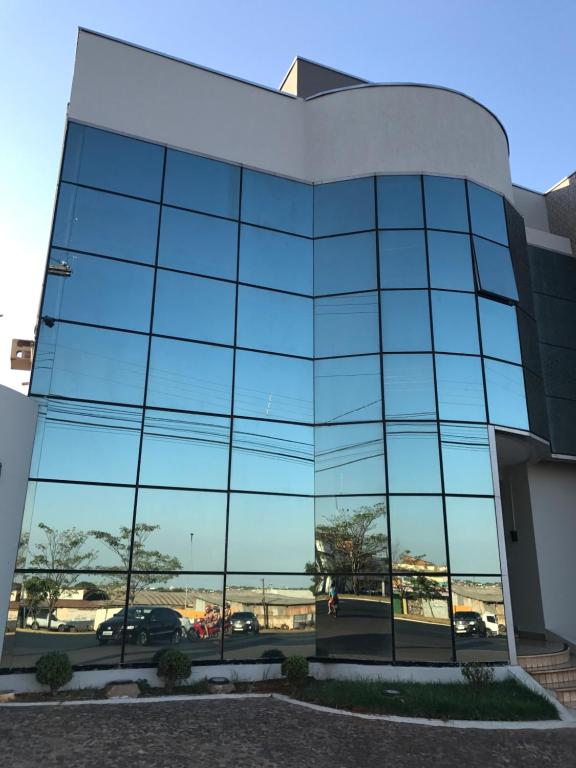 阿拉瓜伊纳Oásis Hotel的享有停车场景致的玻璃建筑