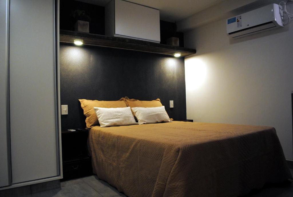 萨尔塔Darwin Apart Hotel的一间卧室配有一张大床和两个枕头