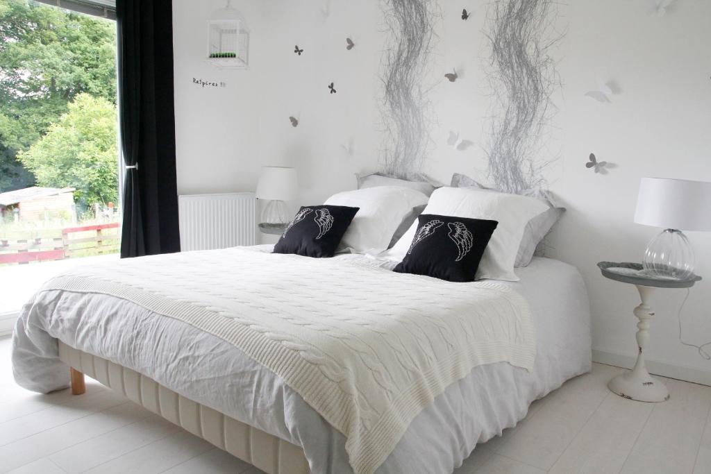 MontenoisChambres d'hôtes Souffle Nature的卧室配有白色的床和黑白色枕头