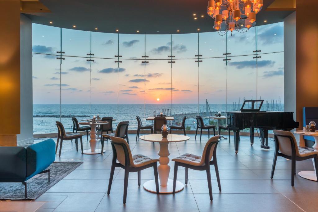 特拉维夫希律特拉维夫海滨酒店的一间享有海景的餐厅,配有钢琴