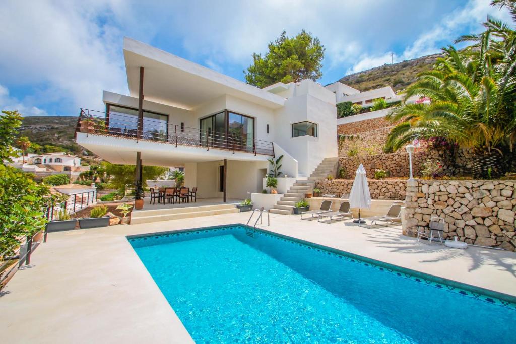莫莱拉Laja - panoramic hillside holiday house in Moraira的别墅前设有游泳池