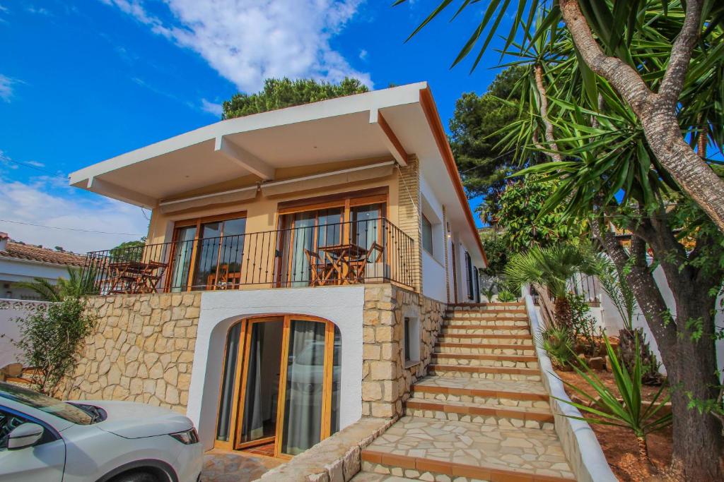 莫莱拉Pedro - two story holiday home villa in El Portet的带阳台的房屋,设有楼梯