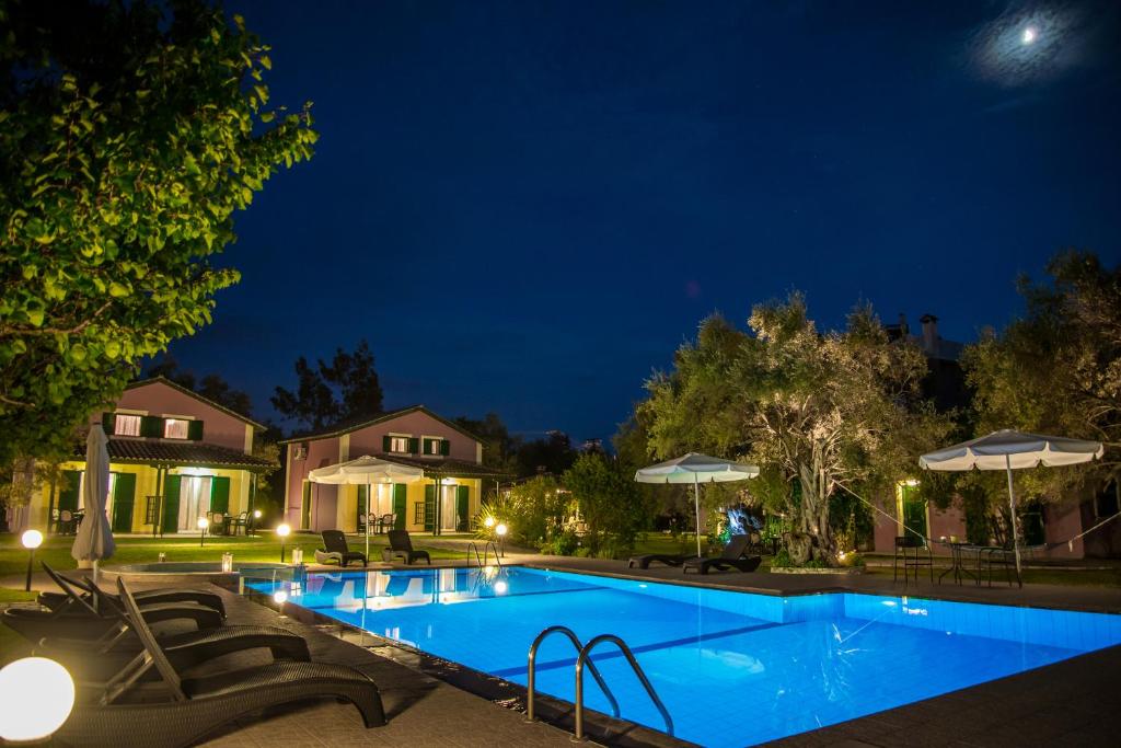 雷夫卡达镇Iliana Villas的夜间在房子里的一个游泳池
