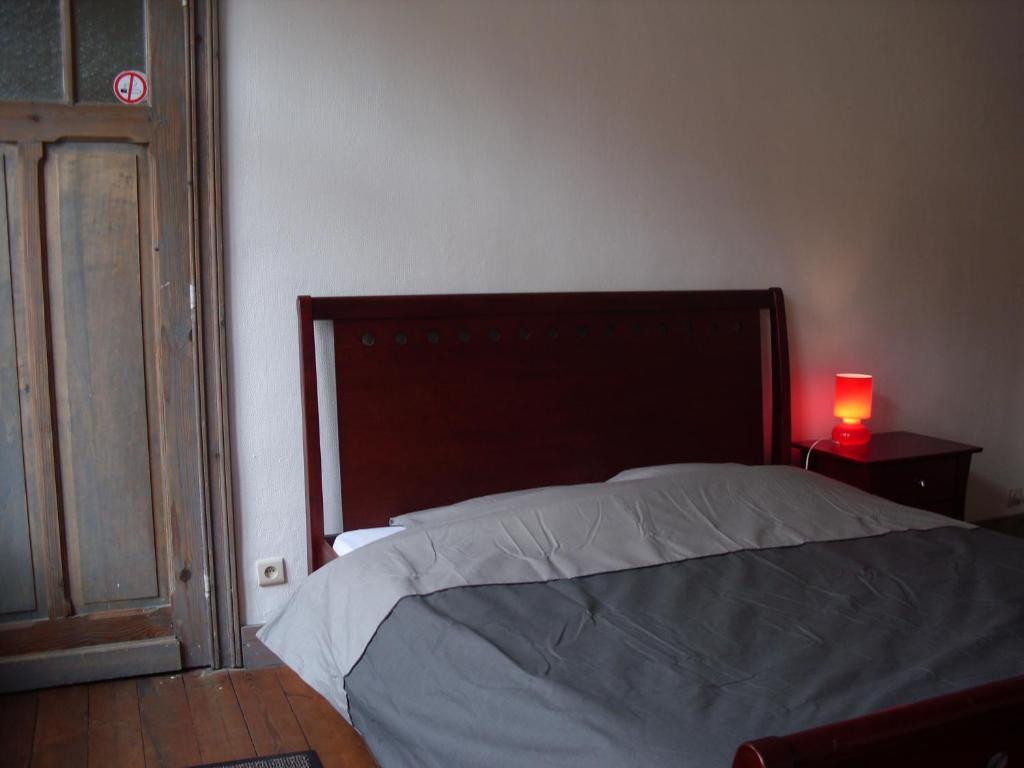 伊普尔Guesthouse Oude Houtmarkt的一间卧室配有一张床和一张桌子上的红灯
