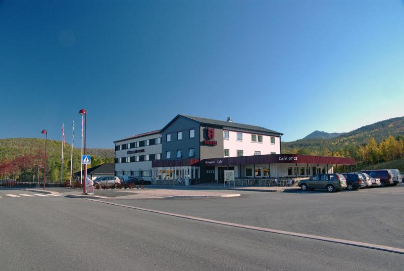 InnhavetHamarøy Hotel的停车场内停放汽车的大型建筑