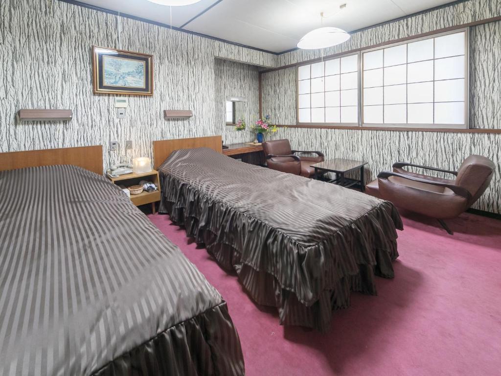 高知昭荣河滨日式旅馆的酒店客房带两张床,还有一间候机室