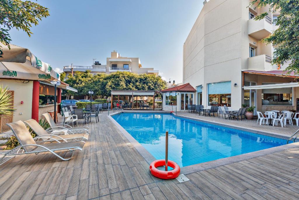 海若克利欧索菲亚酒店的一座带桌椅的游泳池位于酒店大楼旁