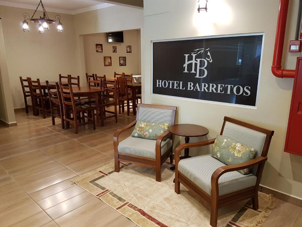 巴雷图斯Hotel Barretos的一间设有桌椅的餐厅,墙上有大标志