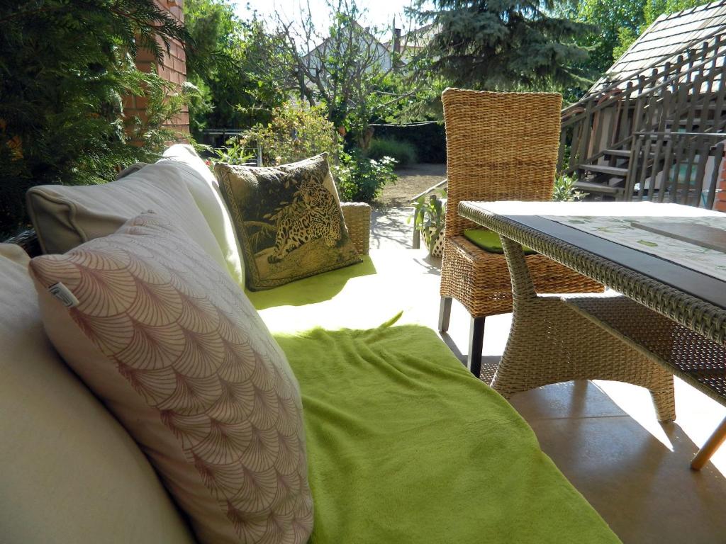 布达厄尔什Helga Vendégház的庭院配有桌椅和枕头。