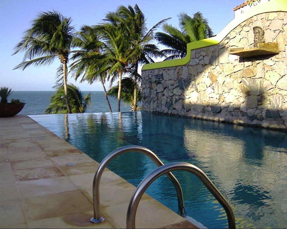 考卡亚Barbanera Club & Hotel de Charme的一座棕榈树和石墙的游泳池