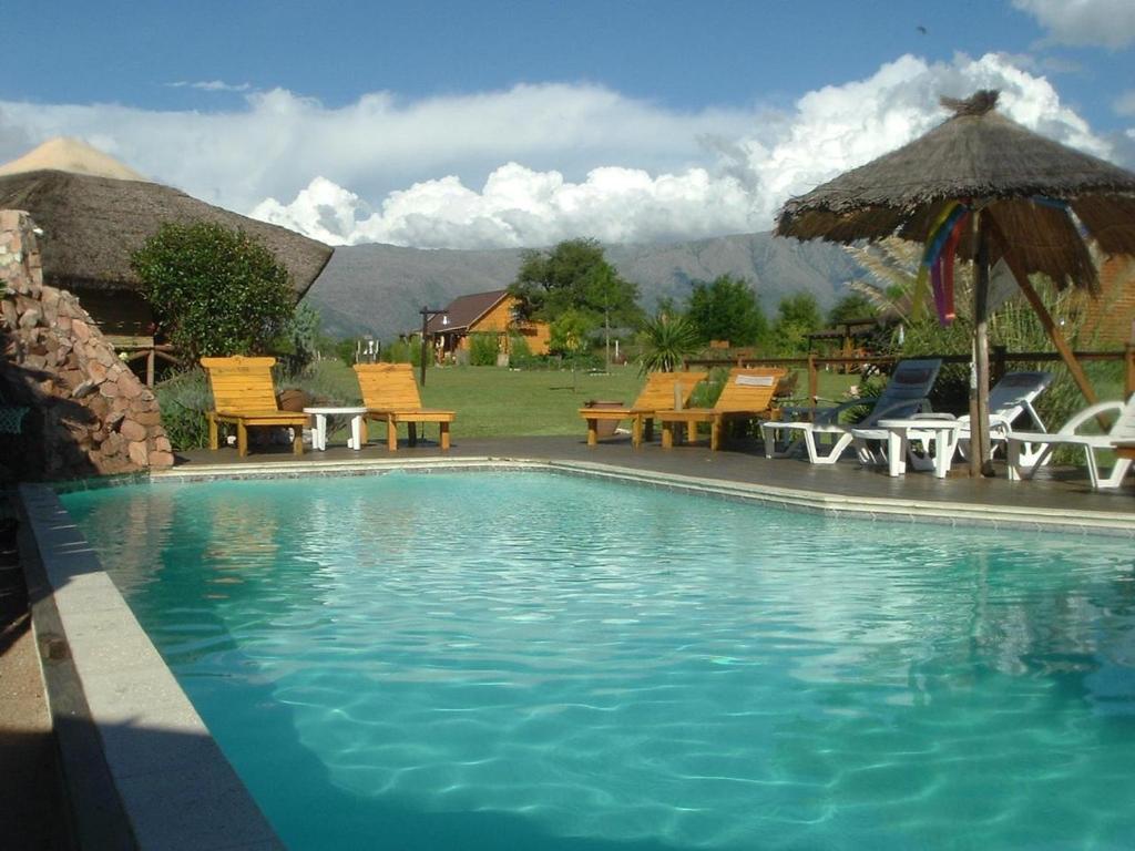 诺诺Rancho Paradise - Adults Only的一个带椅子和遮阳伞的游泳池