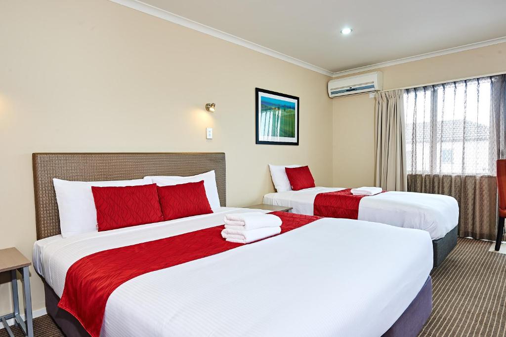 奥克兰奥克兰机场酒店 的酒店客房 - 带两张带红色枕头的床