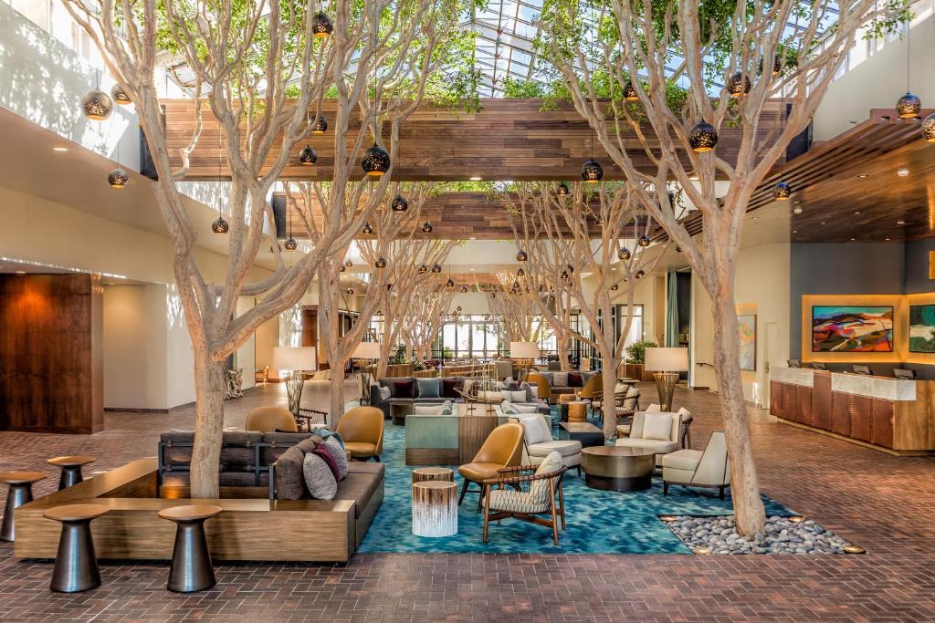 蒙特雷波托拉Spa酒店的大堂设有树木、沙发和桌子